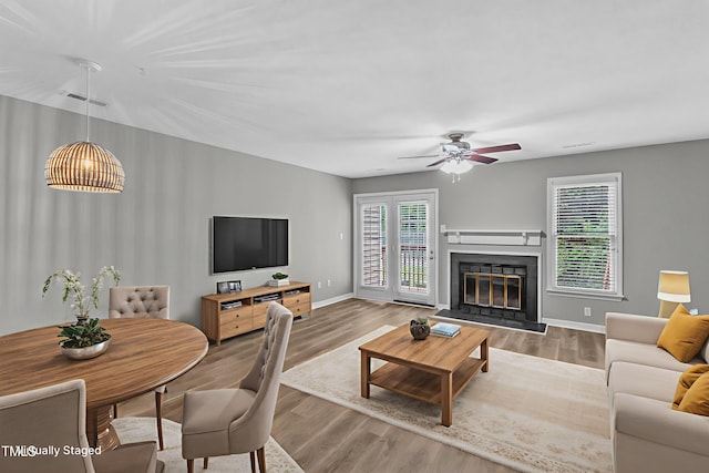 4658 Fawnbrook Cir, Raleigh, NC 27612 - living area featuring ceiling fan, wood finished floors, baseboards, and a glass covered fireplace