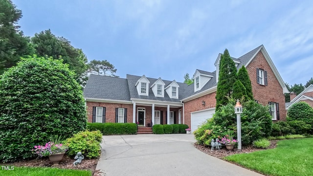 119 Georgetowne Dr, Elon, NC 27244 - cape cod-style house with brick siding, concrete driveway, an attached garage, and a shingled roof