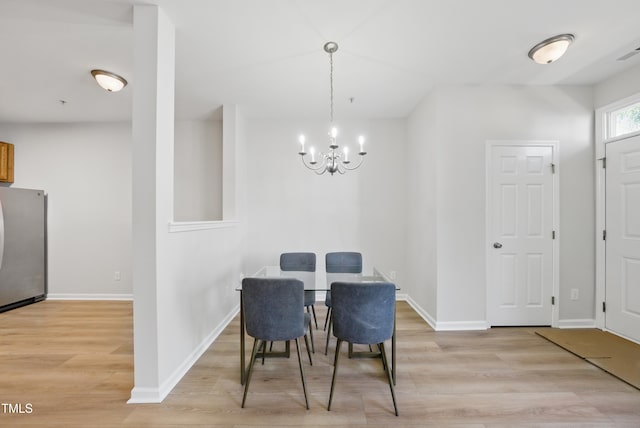 8621 Neuse Club Ln Unit 106, Raleigh, NC 27616 - dining area featuring light wood finished floors, a chandelier, and baseboards