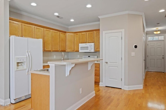 2822 Pickett Rd Unit 132, Durham, NC 27705 - kitchen featuring white appliances, light countertops, a kitchen island with sink, a kitchen breakfast bar, and light wood finished floors