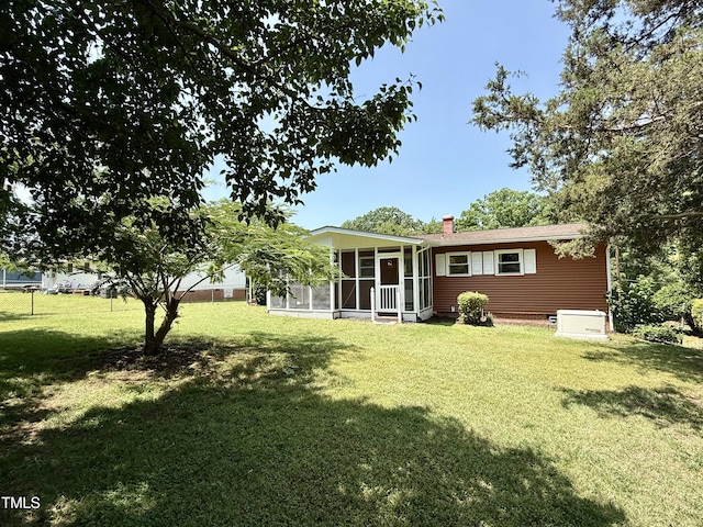 2909 Sprucewood Dr, Durham, NC 27707 - rear view of house with a sunroom, a yard, and a chimney