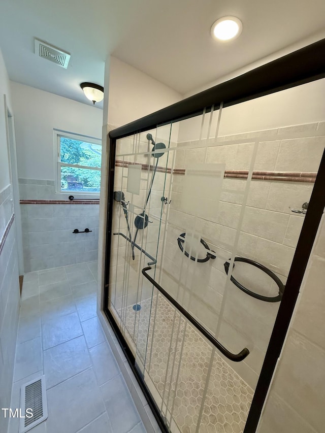 2909 Sprucewood Dr, Durham, NC 27707 - full bathroom with tile walls, a shower stall, tile patterned flooring, and wainscoting