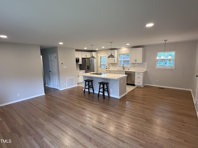 2909 Sprucewood Dr, Durham, NC 27707 - kitchen with a sink, a chandelier, a kitchen island, stainless steel appliances, and white cabinets