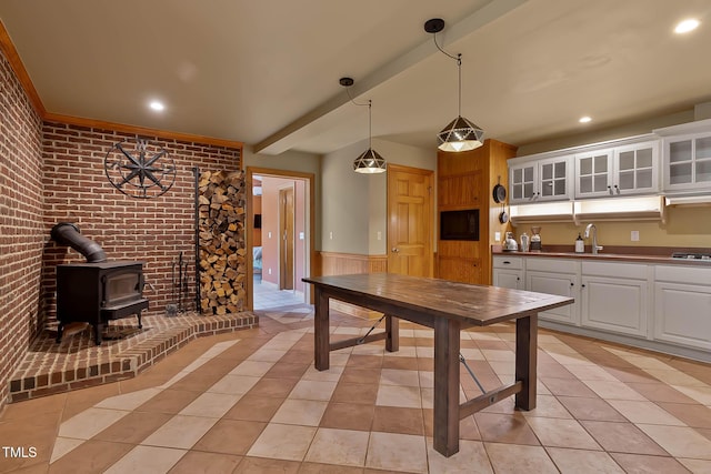145 Ryan Rd, Pittsboro, NC 27312 - kitchen featuring a wood stove, white cabinets, a sink, gas cooktop, and wainscoting