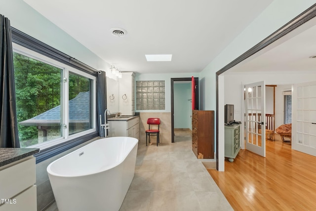 6617 Whitted Rd, Fuquay Varina, NC 27526 - bathroom with vanity, a soaking tub, a skylight, and french doors