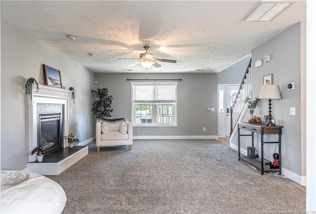 191 Trenton Pl, Cameron, NC 28326 - carpeted living area featuring a ceiling fan, stairs, a glass covered fireplace, baseboards, and a textured ceiling
