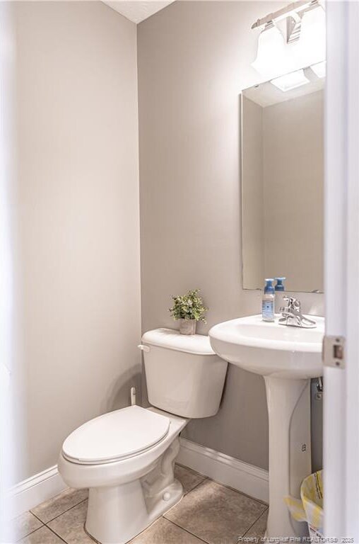 191 Trenton Pl, Cameron, NC 28326 - bathroom with tile patterned floors, toilet, baseboards, and a sink