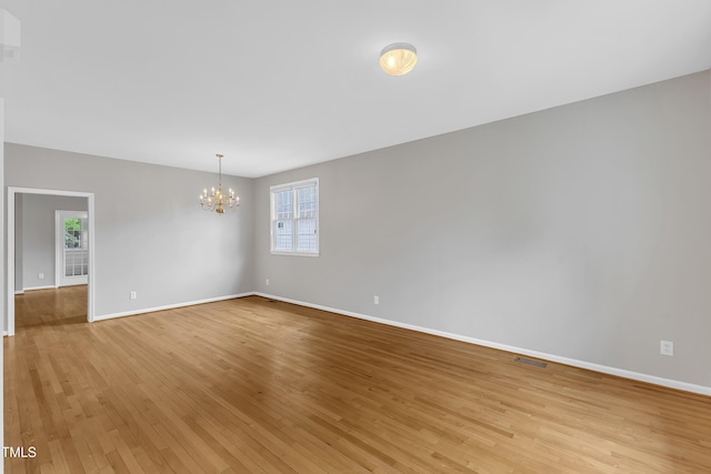 103 Kylie Savannah Ct, Cary, NC 27511 - spare room featuring a chandelier, baseboards, and light wood finished floors