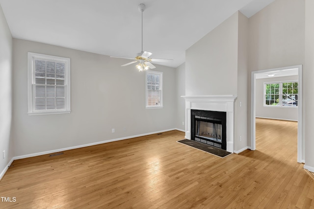 103 Kylie Savannah Ct, Cary, NC 27511 - unfurnished living room with light wood-style floors, a fireplace with flush hearth, ceiling fan, vaulted ceiling, and baseboards