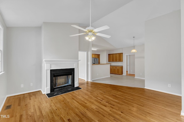 103 Kylie Savannah Ct, Cary, NC 27511 - unfurnished living room featuring a ceiling fan, baseboards, light wood-type flooring, a fireplace, and high vaulted ceiling