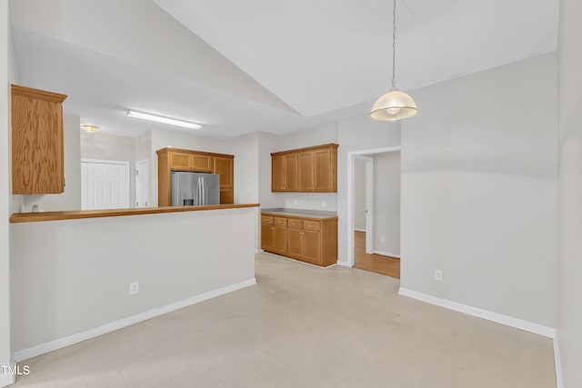 103 Kylie Savannah Ct, Cary, NC 27511 - kitchen featuring stainless steel fridge with ice dispenser, vaulted ceiling, brown cabinetry, baseboards, and decorative light fixtures