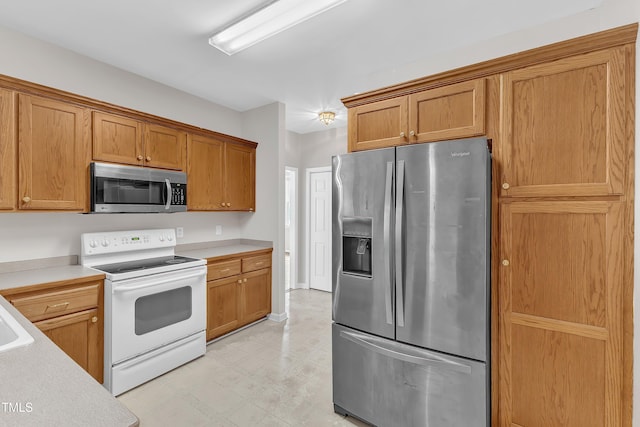 103 Kylie Savannah Ct, Cary, NC 27511 - kitchen featuring stainless steel appliances, light flooring, light countertops, and brown cabinetry