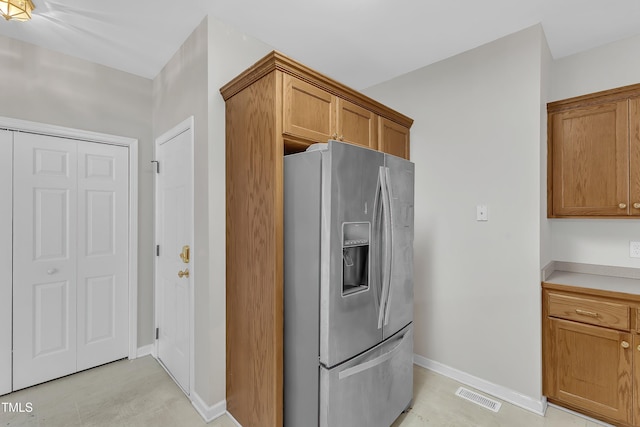 103 Kylie Savannah Ct, Cary, NC 27511 - kitchen with stainless steel fridge with ice dispenser, brown cabinets, baseboards, and light countertops