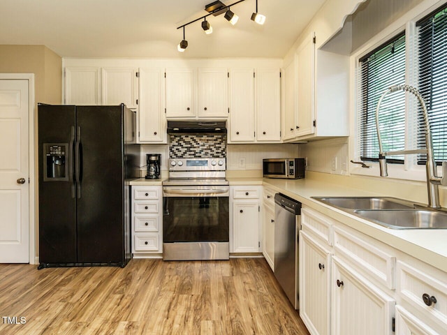 8204 Charlbert Ct, Apex, NC 27539 - kitchen featuring stainless steel appliances, under cabinet range hood, a sink, light countertops, and light wood-type flooring