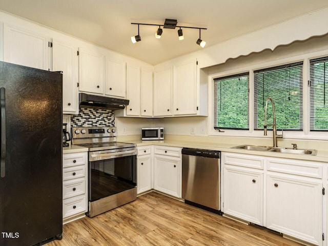 8204 Charlbert Ct, Apex, NC 27539 - kitchen featuring stainless steel appliances, under cabinet range hood, a sink, light countertops, and white cabinetry
