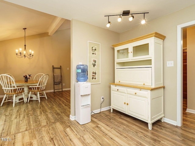 8204 Charlbert Ct, Apex, NC 27539 - dining room with light wood finished floors, a chandelier, baseboards, and rail lighting