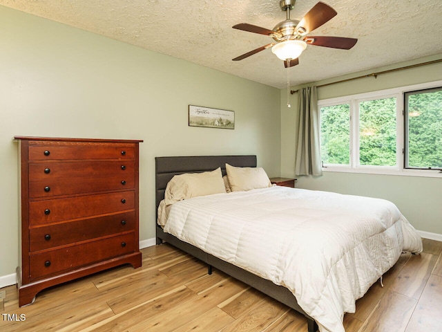 8204 Charlbert Ct, Apex, NC 27539 - bedroom featuring light wood-style flooring, a textured ceiling, baseboards, and a ceiling fan