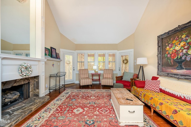 6035 Sentinel Dr, Raleigh, NC 27609 - living room featuring high vaulted ceiling, wood finished floors, and a stone fireplace