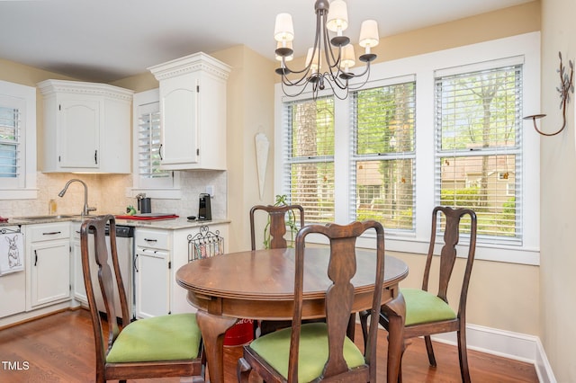 6035 Sentinel Dr, Raleigh, NC 27609 - dining room with a chandelier, dark wood finished floors, and baseboards