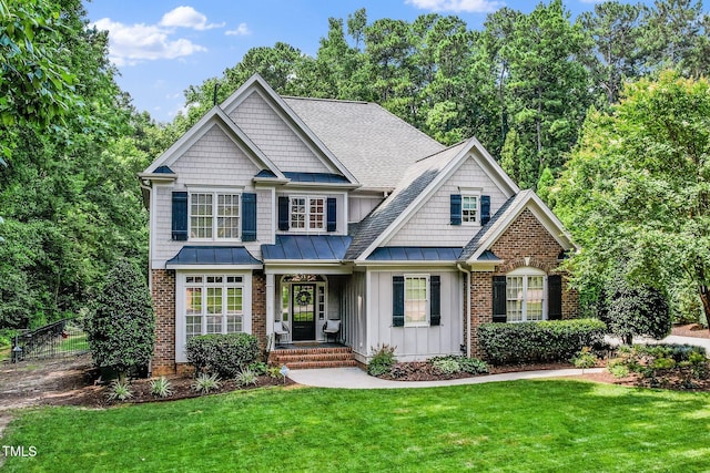 3748 Westbury Lake Dr, Raleigh, NC 27603 - craftsman-style home featuring a standing seam roof, board and batten siding, a front yard, and brick siding