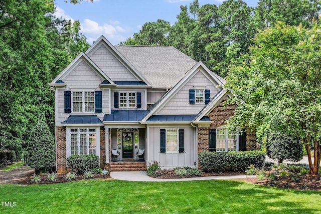 3748 Westbury Lake Dr, Raleigh, NC 27603 - craftsman house featuring a porch, a standing seam roof, brick siding, a front yard, and a shingled roof