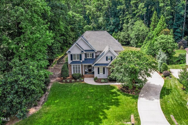 3748 Westbury Lake Dr, Raleigh, NC 27603 - craftsman house featuring a standing seam roof, a front yard, covered porch, board and batten siding, and a metal roof