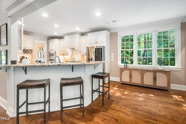 3748 Westbury Lake Dr, Raleigh, NC 27603 - kitchen featuring smart refrigerator, built in microwave, ornamental molding, backsplash, and a kitchen breakfast bar