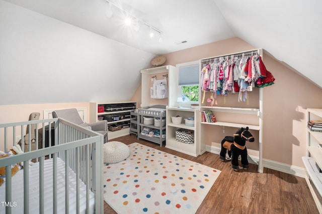 3748 Westbury Lake Dr, Raleigh, NC 27603 - bedroom featuring track lighting, wood finished floors, vaulted ceiling, and a crib