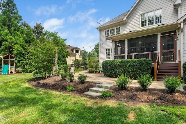 3748 Westbury Lake Dr, Raleigh, NC 27603 - rear view of house with a sunroom, a lawn, and a playground