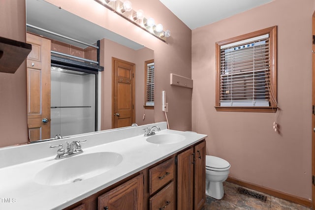 5437 Grasshopper Rd, Raleigh, NC 27610 - bathroom featuring double vanity, toilet, baseboards, stone finish flooring, and a shower