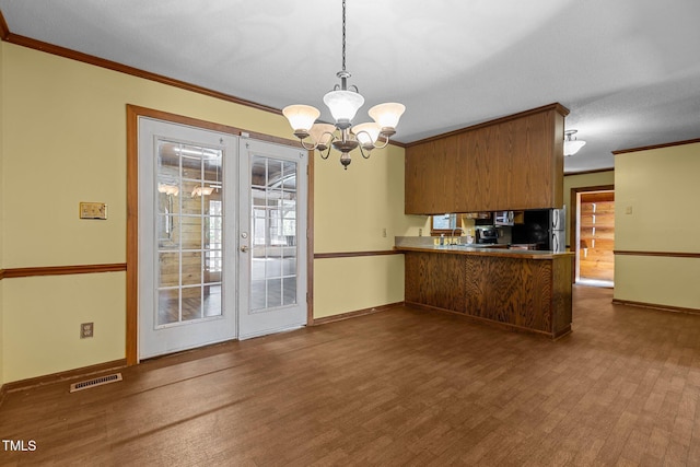 5437 Grasshopper Rd, Raleigh, NC 27610 - kitchen with freestanding refrigerator, ornamental molding, a chandelier, wood finished floors, and french doors