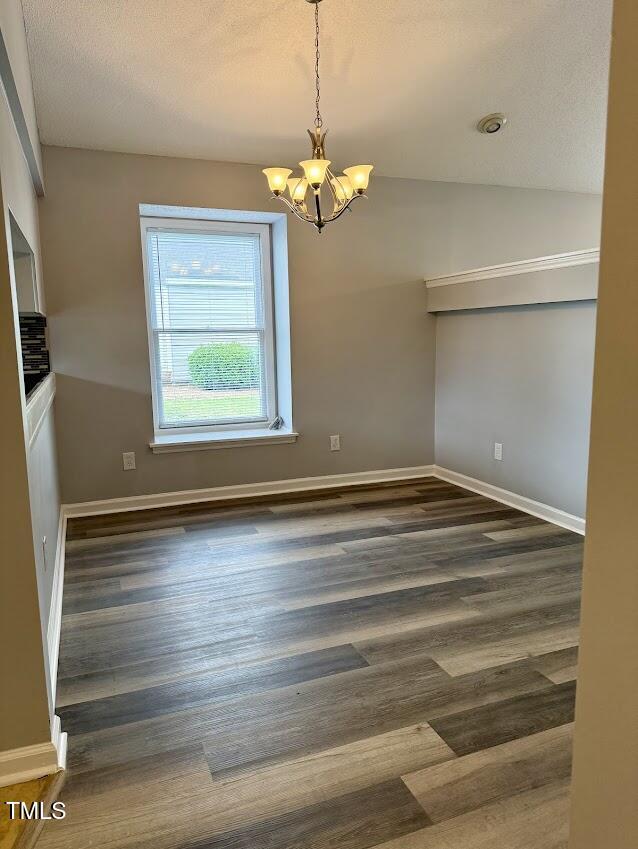 5071 Avenida Del Sol Dr, Raleigh, NC 27616 - spare room with a chandelier, wood finished floors, baseboards, and vaulted ceiling