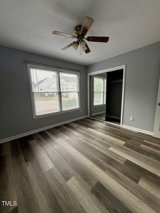 5071 Avenida Del Sol Dr, Raleigh, NC 27616 - unfurnished bedroom with a textured ceiling, baseboards, wood finished floors, a closet, and ceiling fan