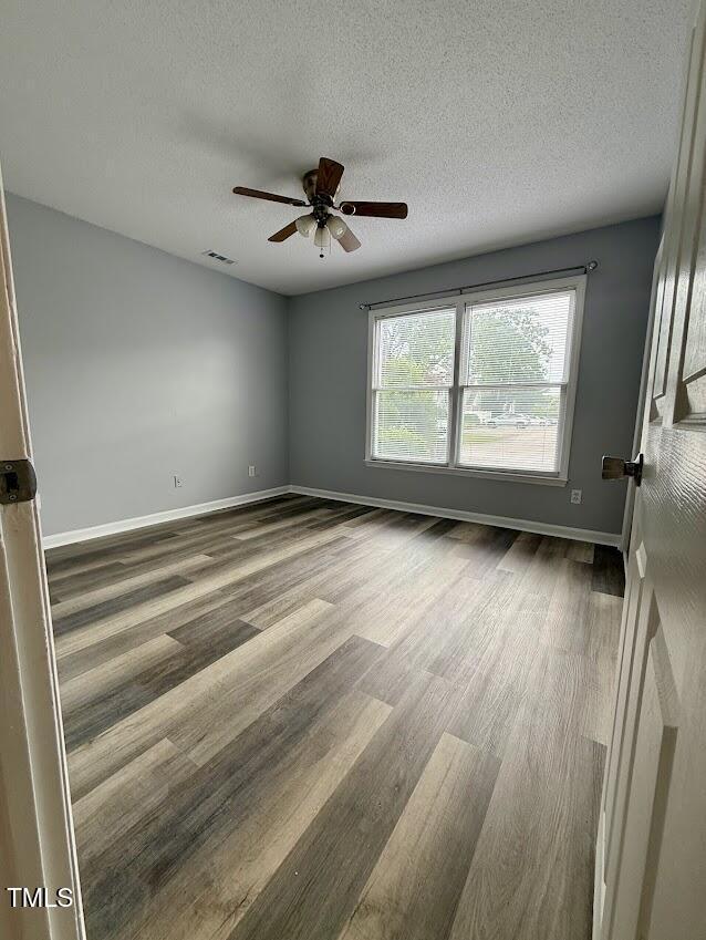 5071 Avenida Del Sol Dr, Raleigh, NC 27616 - spare room with ceiling fan, wood finished floors, baseboards, and a textured ceiling