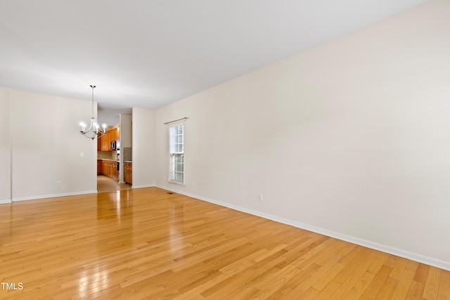 1405 Merrilow Ct, Wake Forest, NC 27587 - unfurnished room with a chandelier, light wood-style flooring, and baseboards