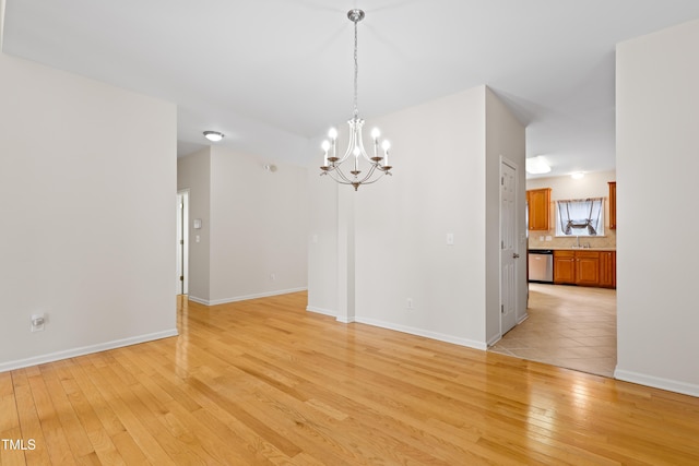 1405 Merrilow Ct, Wake Forest, NC 27587 - spare room with a chandelier, light wood finished floors, a sink, and baseboards