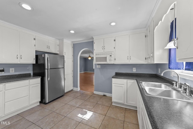 282 Cooke Rd, Louisburg, NC 27549 - kitchen with freestanding refrigerator, a sink, white microwave, white cabinets, and dark countertops