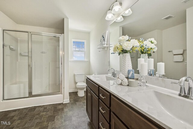 225 Rosewood Ln, Youngsville, NC 27596 - full bathroom featuring toilet, baseboards, a shower stall, double vanity, and stone finish floors