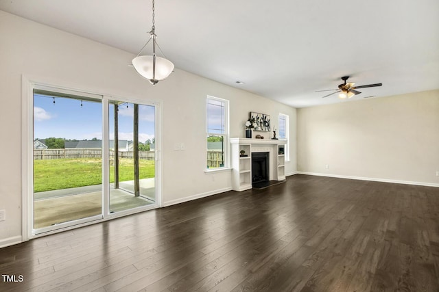 225 Rosewood Ln, Youngsville, NC 27596 - unfurnished living room featuring a ceiling fan, plenty of natural light, dark wood-type flooring, and baseboards