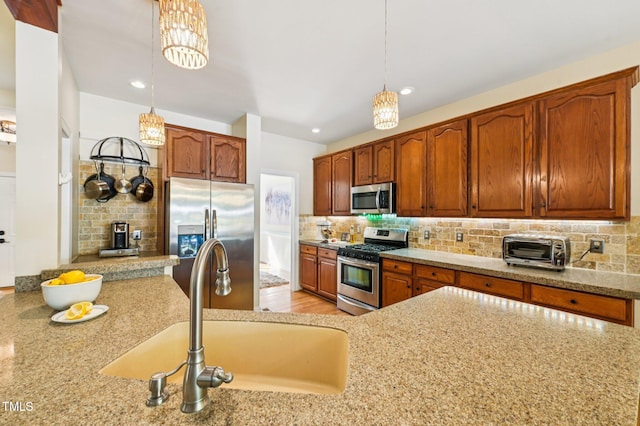 6829 Wood Forest Dr, Cary, NC 27519 - kitchen with stainless steel appliances, backsplash, hanging light fixtures, light stone counters, and recessed lighting