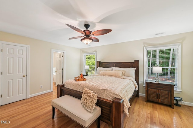 6829 Wood Forest Dr, Cary, NC 27519 - bedroom with light wood finished floors, ceiling fan, and connected bathroom