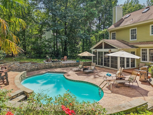 6829 Wood Forest Dr, Cary, NC 27519 - outdoor pool with a patio area, an outdoor fire pit, and a sunroom