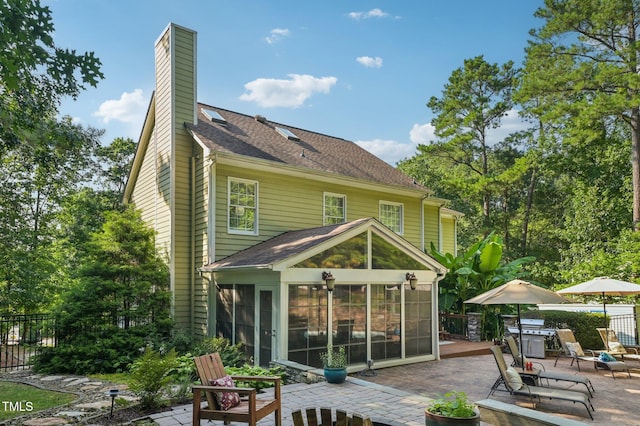 6829 Wood Forest Dr, Cary, NC 27519 - rear view of property with a patio area, a sunroom, a chimney, and a shingled roof