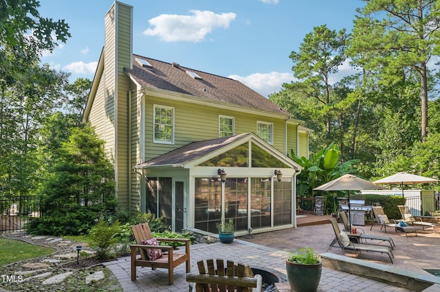 6829 Wood Forest Dr, Cary, NC 27519 - rear view of property with a patio area, a sunroom, a chimney, and a shingled roof