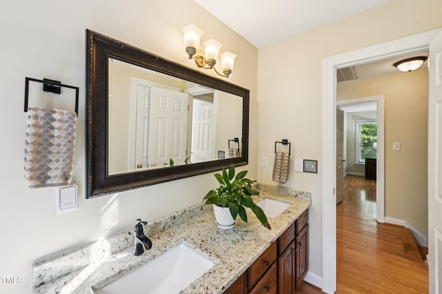 6829 Wood Forest Dr, Cary, NC 27519 - bathroom featuring wood finished floors, double vanity, and a chandelier