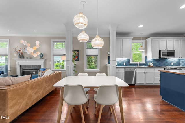10579 Evergreen Spring Pl, Raleigh, NC 27614 - kitchen featuring appliances with stainless steel finishes, ornamental molding, backsplash, dark wood finished floors, and ornate columns