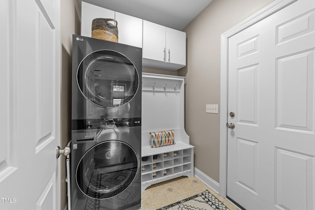 10579 Evergreen Spring Pl, Raleigh, NC 27614 - washroom featuring stacked washer / dryer, cabinet space, baseboards, and light tile patterned flooring