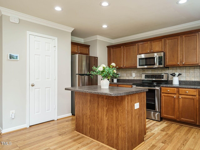 1833 Creek Oak Cir, Fuquay Varina, NC 27526 - kitchen featuring appliances with stainless steel finishes, dark countertops, a center island, light wood-type flooring, and tasteful backsplash