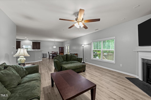 2709 Banks Lake Ct, Fuquay Varina, NC 27526 - living room with light wood-type flooring, healthy amount of natural light, a ceiling fan, and a fireplace with flush hearth