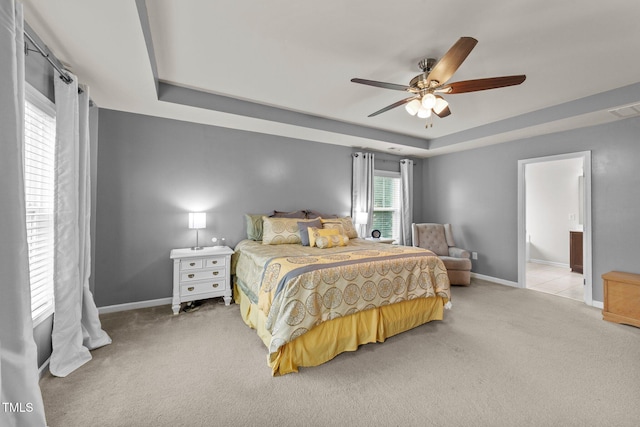 2709 Banks Lake Ct, Fuquay Varina, NC 27526 - bedroom featuring light colored carpet, a tray ceiling, baseboards, ceiling fan, and connected bathroom